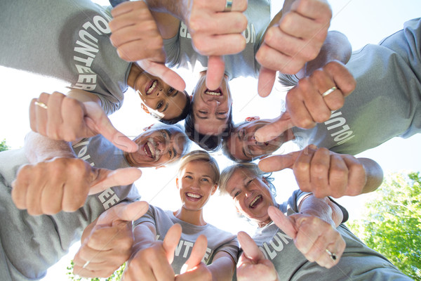 Happy volunteer family looking down with thumbs up  Stock photo © wavebreak_media