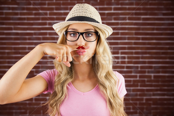 A beautiful hipster having a fake distinguished mustache  Stock photo © wavebreak_media