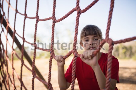 Portrait of happy girl climbing a net during obstacle course Stock photo © wavebreak_media