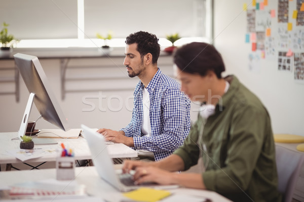 Young businessman working on desktop pc at desk Stock photo © wavebreak_media