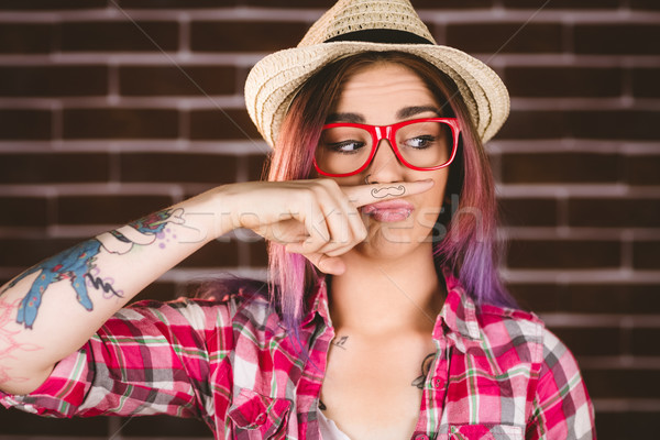 Beautiful woman pretending to have a fake moustache Stock photo © wavebreak_media