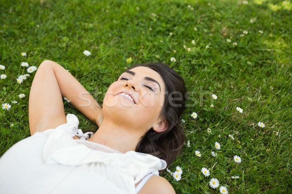 Stock photo: Happy woman relaxing with hand behind head on grassland