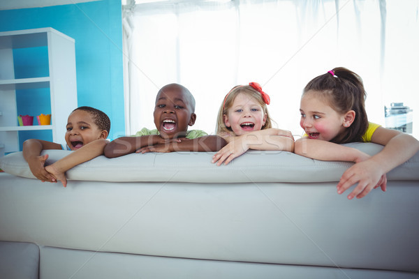 Stock photo: Happy kids looking from the back of the couch