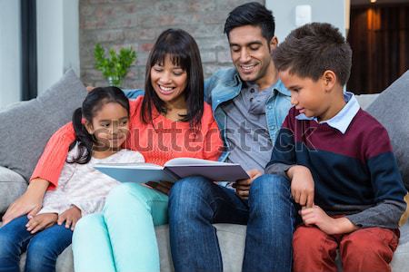 Happy mother being kissed by her children while holding a presen Stock photo © wavebreak_media