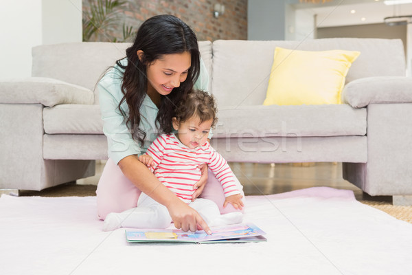 Foto stock: Feliz · madre · bebé · mirando · libro · alfombra