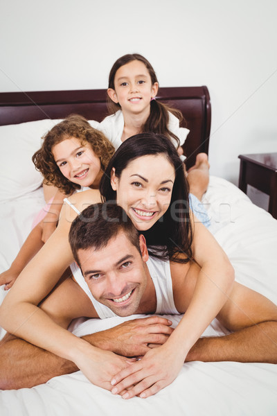 Portrait of cheerful family lying on bed Stock photo © wavebreak_media