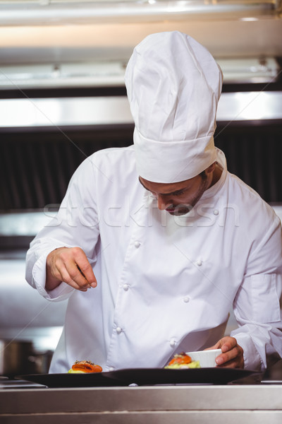 Stock photo: Chef sprinkling spices on dish