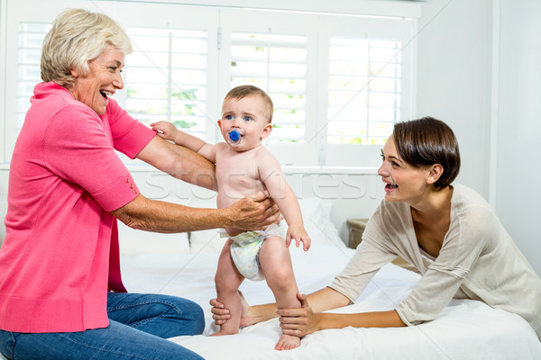 Grandmother and mother holding baby boy on bed Stock photo © wavebreak_media