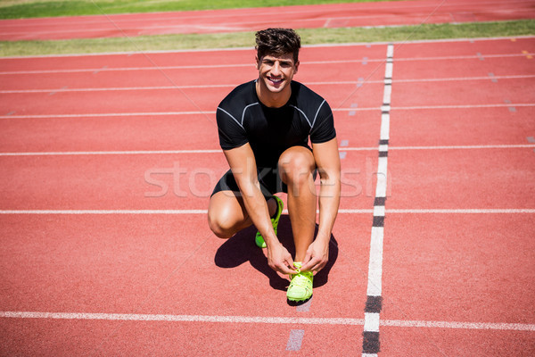 Portrait of male athlete tying her shoe laces on running track Stock photo © wavebreak_media