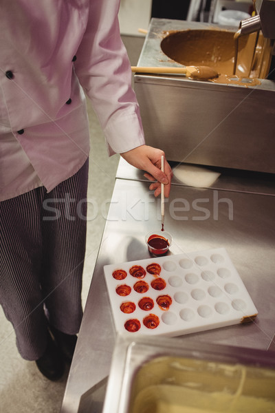 Stock photo: Worker painting a chocolate mould using colored chocolate