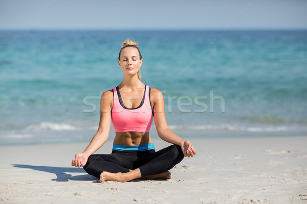 Woman meditating in lotus position at beach Stock photo © wavebreak_media