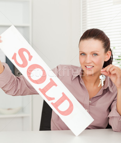 A businesswoman is holding keys and a sold sign Stock photo © wavebreak_media