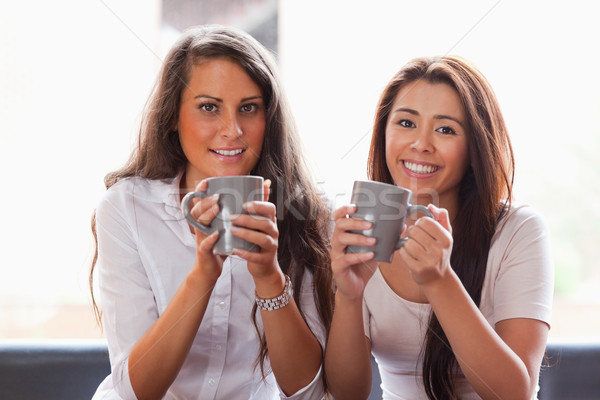 Friends having a cup of coffee while smiling at the camera Stock photo © wavebreak_media