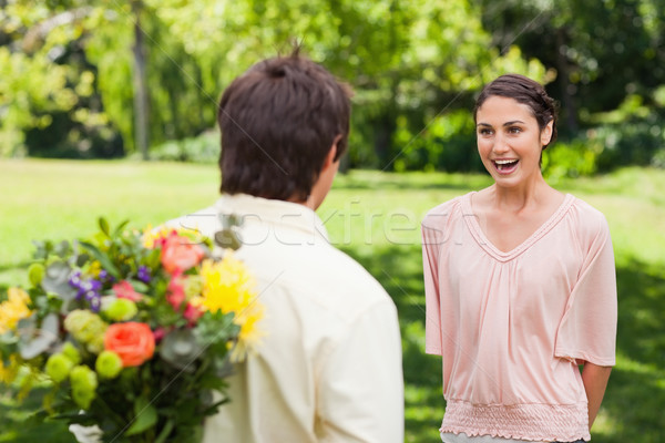 Mujer excitado amigo flores oculto detrás Foto stock © wavebreak_media