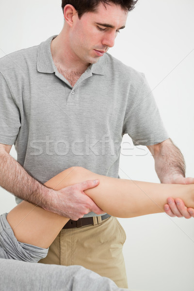 Serious osteopath examining a the leg of his patient in a room Stock photo © wavebreak_media