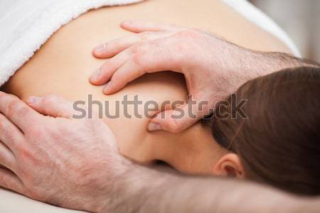 Osteopath massaging his patient while pressing his tumb in a room Stock photo © wavebreak_media