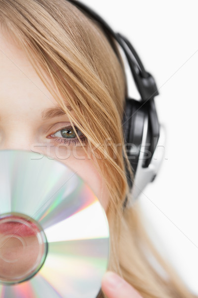 Close up of a blonde woman with a cd in front of her face against a white background Stock photo © wavebreak_media