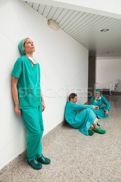 Three surgeons taking break in hospital corridor Stock photo © wavebreak_media