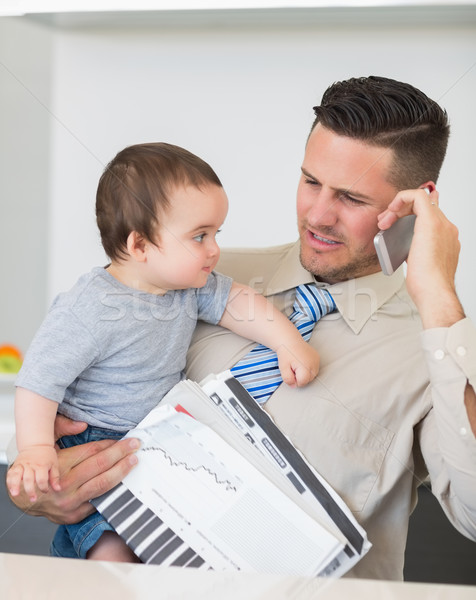 Businessman carrying baby and documents while on call Stock photo © wavebreak_media