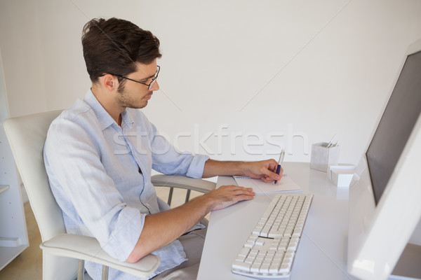 Casuale imprenditore prendere appunti desk ufficio tastiera Foto d'archivio © wavebreak_media