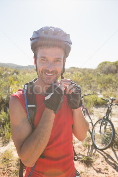 Fit cyclist adjusting helmet strap on country terrain Stock photo © wavebreak_media