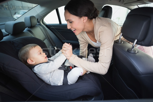 Mother securing her baby in the car seat Stock photo © wavebreak_media