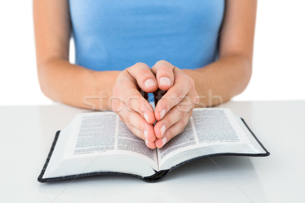 Woman praying while reading bible Stock photo © wavebreak_media