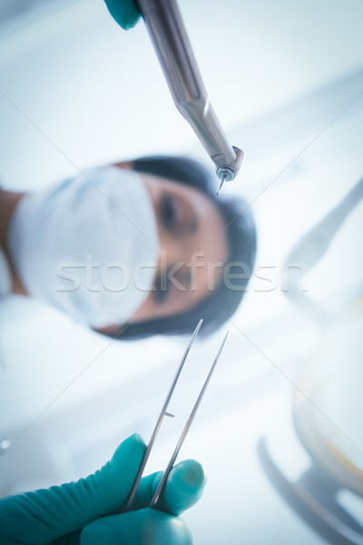 Female dentist in surgical mask holding dental tools Stock photo © wavebreak_media