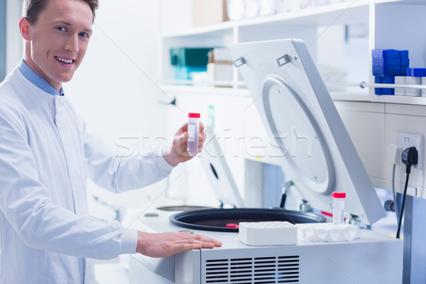 Smiling chemist holding a test tube looking at camera Stock photo © wavebreak_media