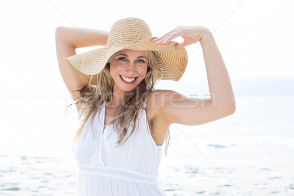 Smiling blonde in white dress looking at camera and wearing stra Stock photo © wavebreak_media