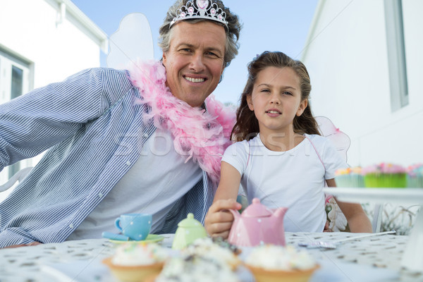 Smiling father and daughter in fairy costume having a tea party Stock photo © wavebreak_media