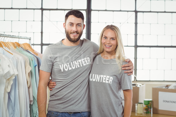 Stock photo: Portrait of joyful volunteers with arms around standing 