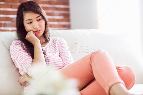 Stock photo: Upset asian woman on couch 