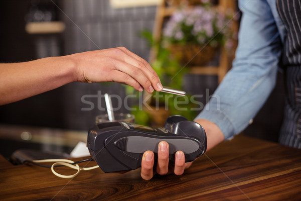 Female customer paying with smartphone Stock photo © wavebreak_media