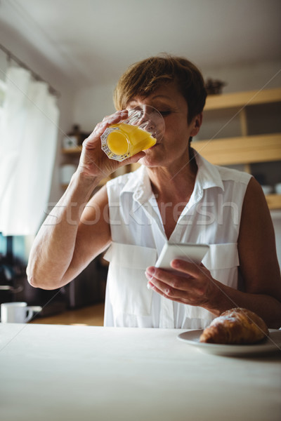 Senior donna cellulare colazione cucina home Foto d'archivio © wavebreak_media