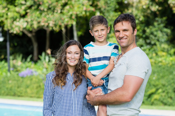 [[stock_photo]]: Souriant · famille · permanent · ensemble · parc · portrait