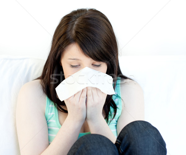 Sick teen girl blowing sitting on a sofa Stock photo © wavebreak_media