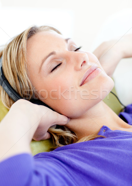 Relaxed woman listen to music lying on a sofa at home Stock photo © wavebreak_media