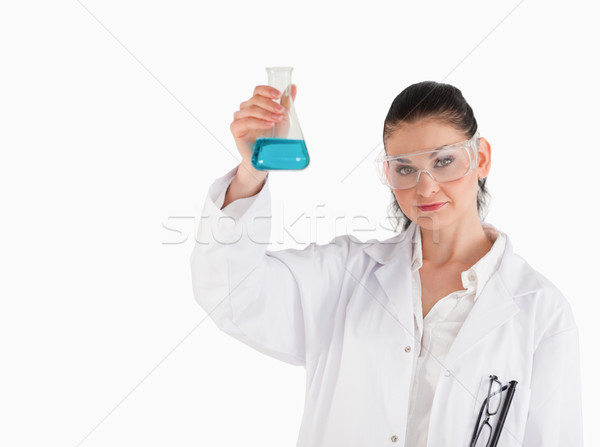Dark-haired scientist holding a blue flask while looking at the camera Stock photo © wavebreak_media
