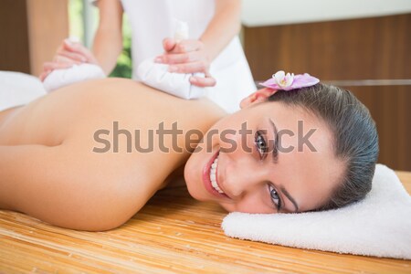 Young red-haired woman in a spa with a potpourri and massage stones next to her Stock photo © wavebreak_media