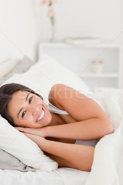 close up of a relaxing dark-haired woman lying under sheet in bedroom Stock photo © wavebreak_media