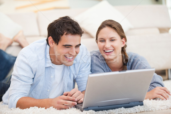 Young Couple lying while using a computer in a sitting room Stock photo © wavebreak_media