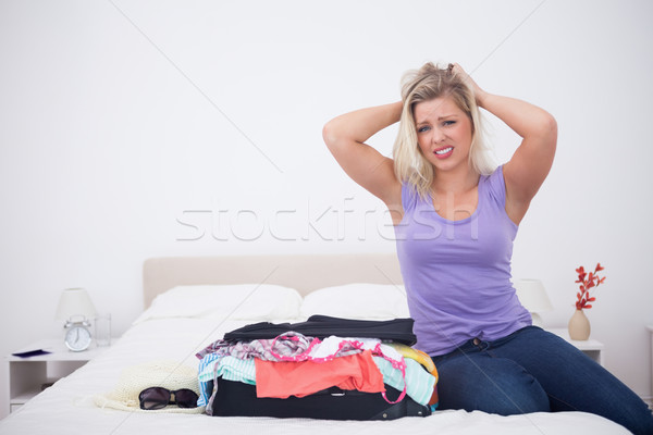 Young woman tearing her hair next to her full suitcase on her bed Stock photo © wavebreak_media