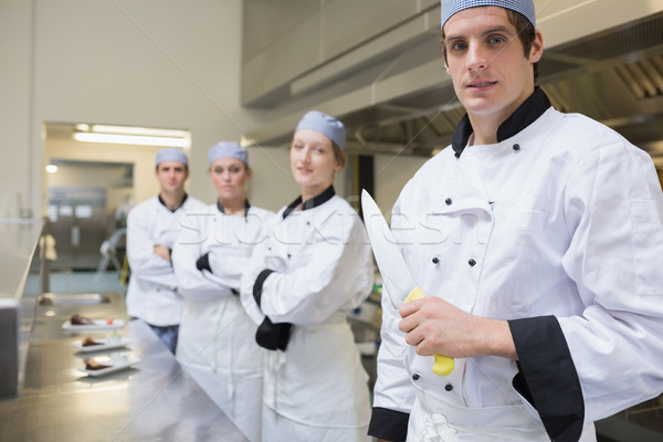 Team of Chef's with one holding a knife in the kitchen Stock photo © wavebreak_media