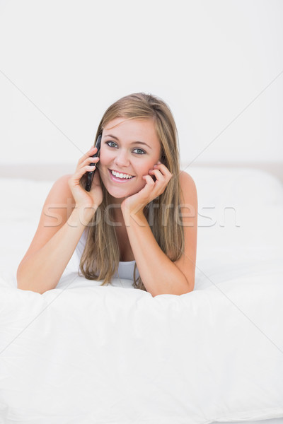 Joyful woman phoning lying on the bed  Stock photo © wavebreak_media