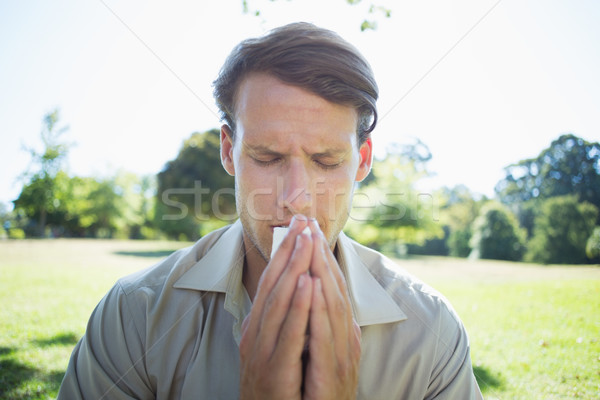 Stylish man blowing his nose in the park Stock photo © wavebreak_media