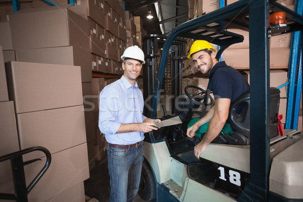 Warehouse manager talking with forklift driver Stock photo © wavebreak_media