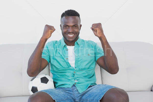 Stock photo: Soccer fan cheering while watching tv