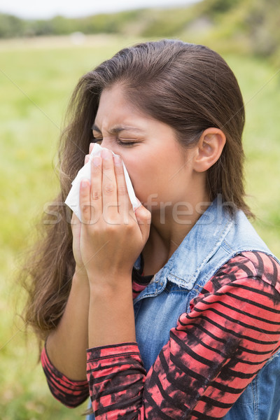 Pretty brunette blowing her nose Stock photo © wavebreak_media