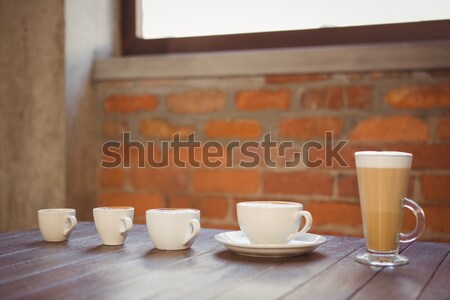 Several hot beverages in a row on wooden table Stock photo © wavebreak_media